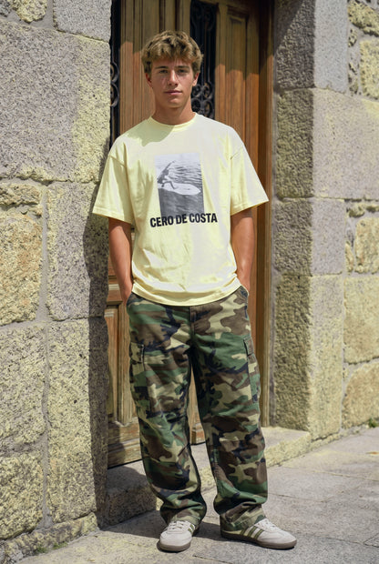 Camiseta mantequilla «Foto Surfer» de Cero de Costa con pantalón de camuflaje, vista de frente